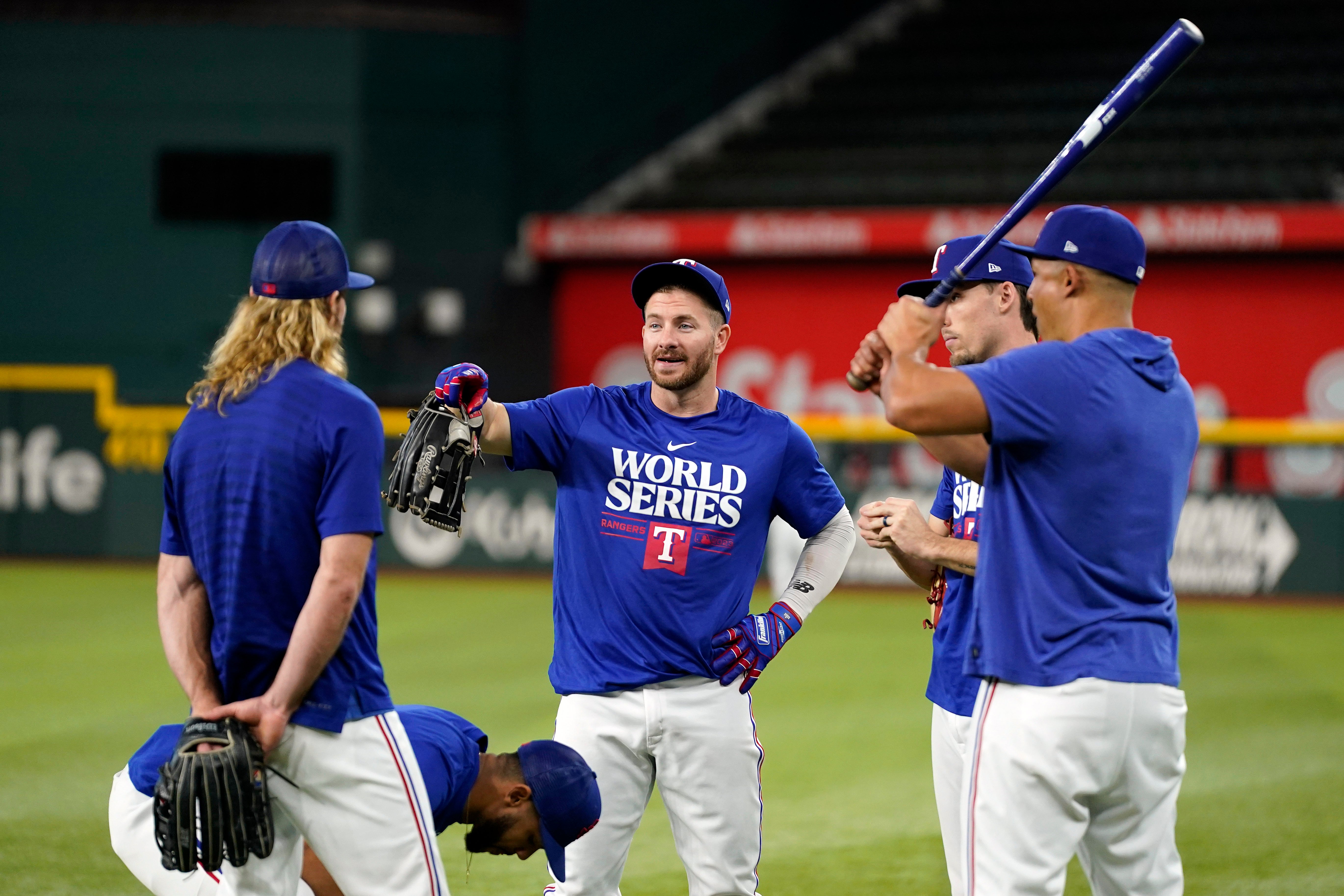 Texas Rangers’ Robbie Grossman, center, talks with teammates