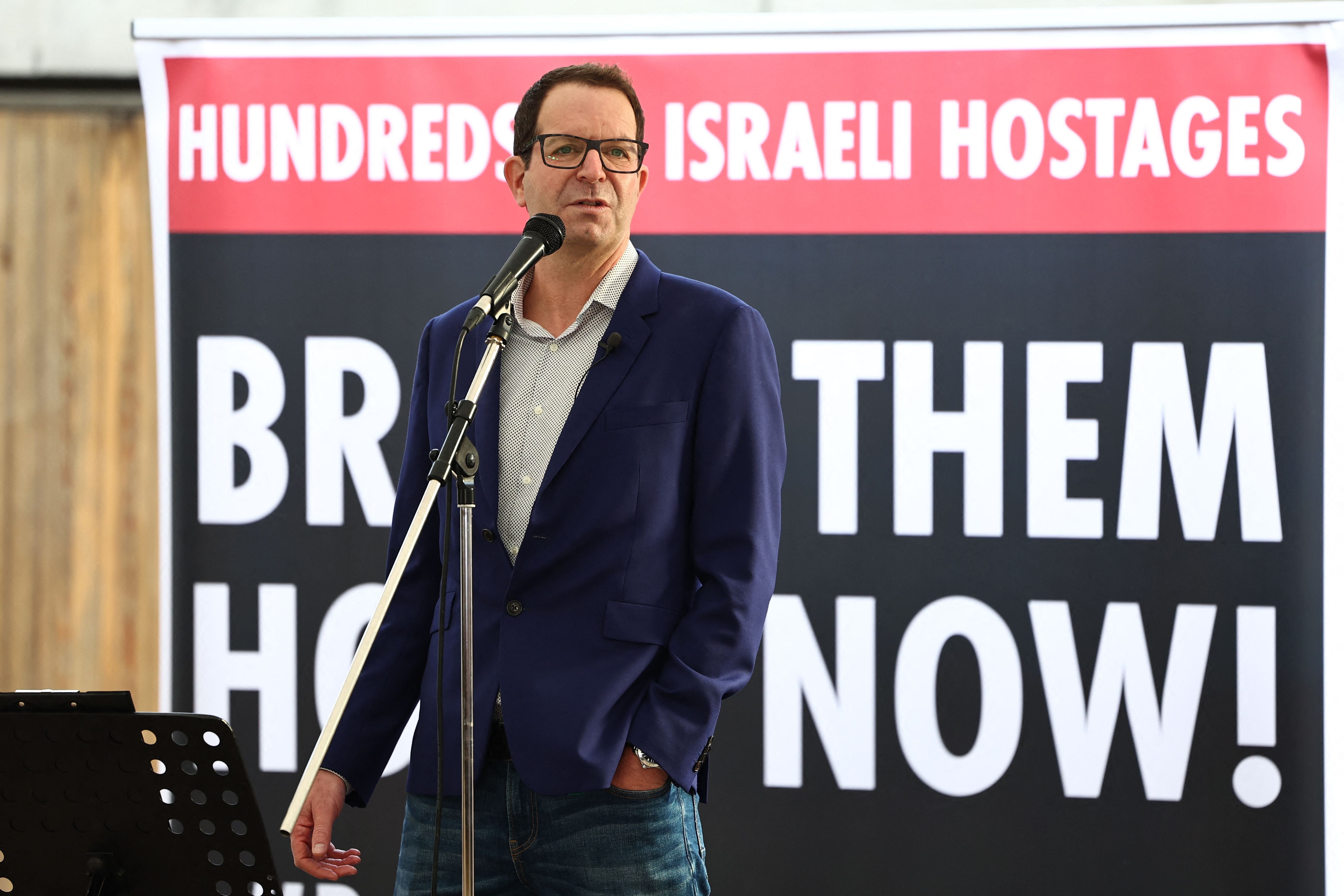 Noam Sagi, son of Ada Sagi, one of the missing Israelis speaks to people viewing the empty places laid out for the 220 hostages on Friday