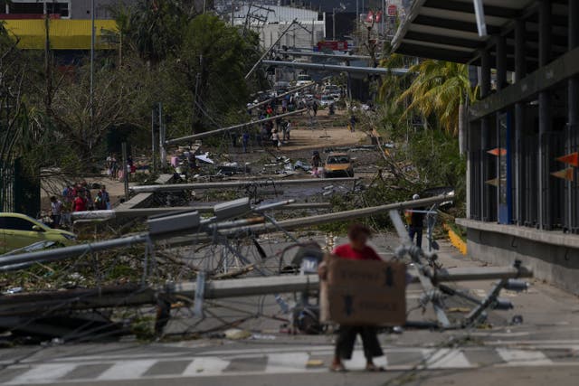 <p>Downed power and telephone poles lay on a street on October 26 after Hurricane Otis ripped through Acapulco </p>