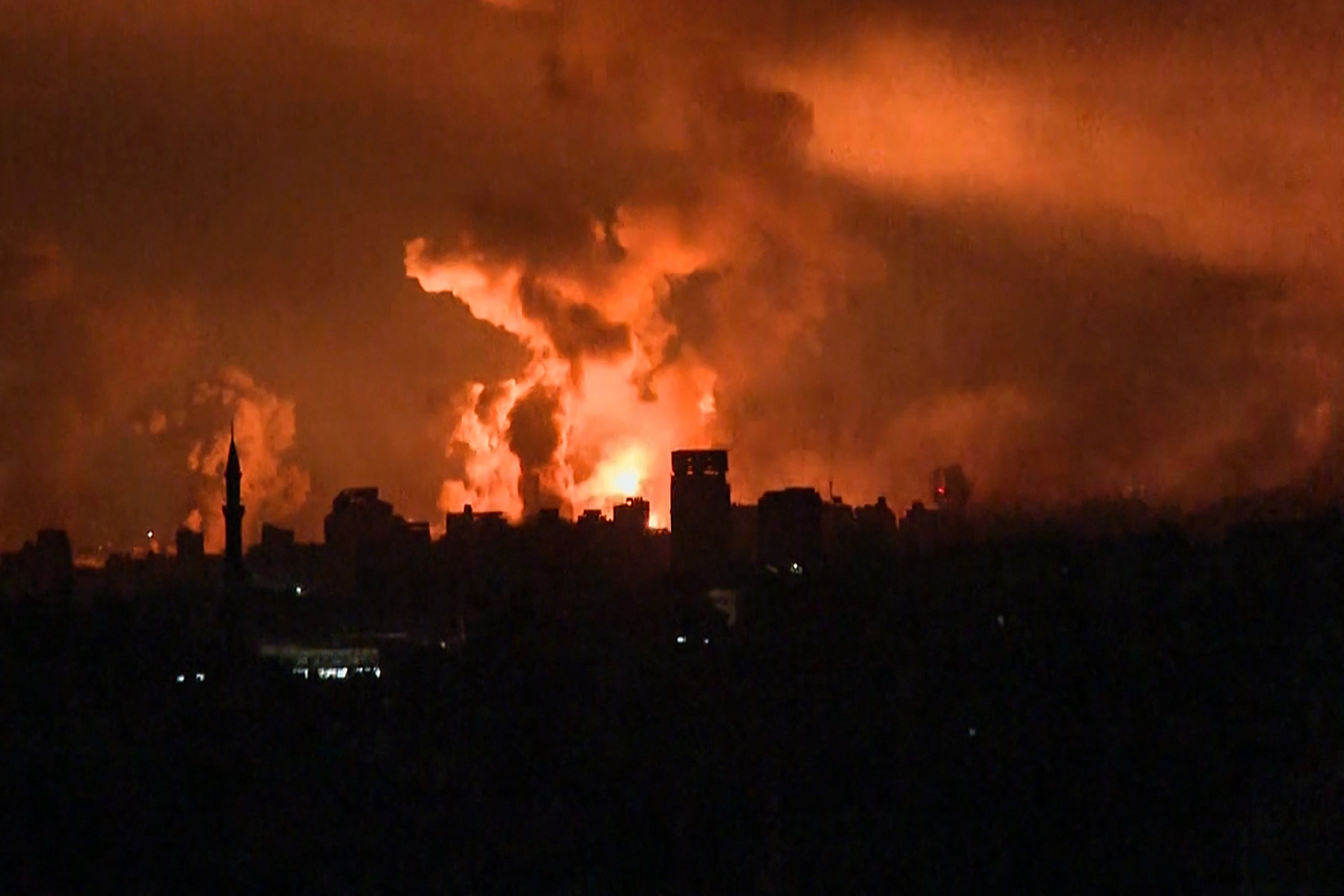 Balls of fire rise above Gaza City on Friday during an Israeli strike