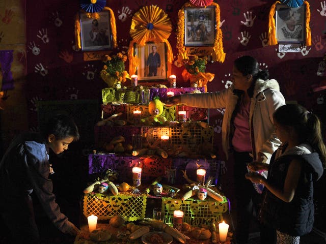 <p>People gather in front of an altar in honour of the victims of Mexico’s September 19 earthquake, in the site of a collapsed building at Tlalpan neighbourhood in Mexico City, on 1 November 2017. </p>