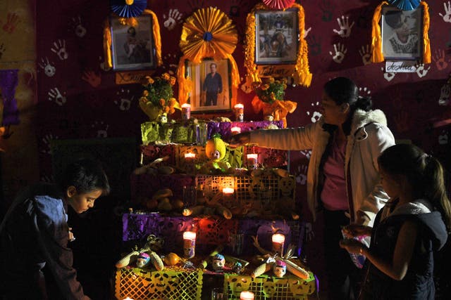 <p>People gather in front of an altar in honour of the victims of Mexico’s September 19 earthquake, in the site of a collapsed building at Tlalpan neighbourhood in Mexico City, on 1 November 2017. </p>