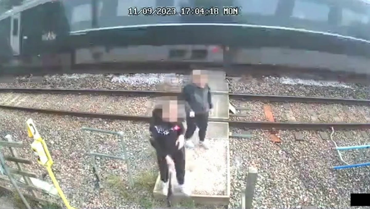 Children push each other as train speeds past on level crossing  in shocking CCTV