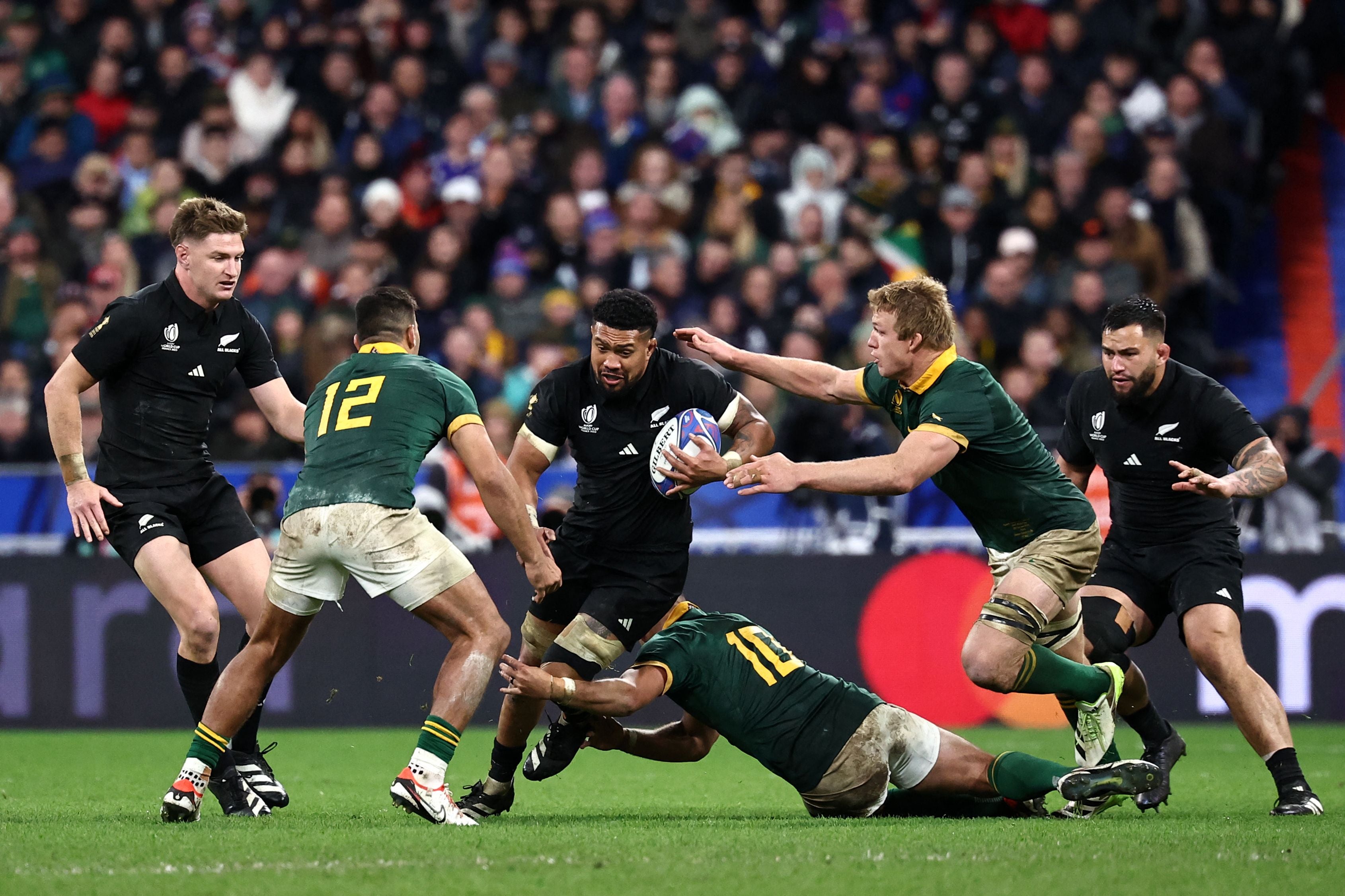 New Zealand’s number eight Ardie Savea is tackled by South Africa’s fly-half Handre Pollard