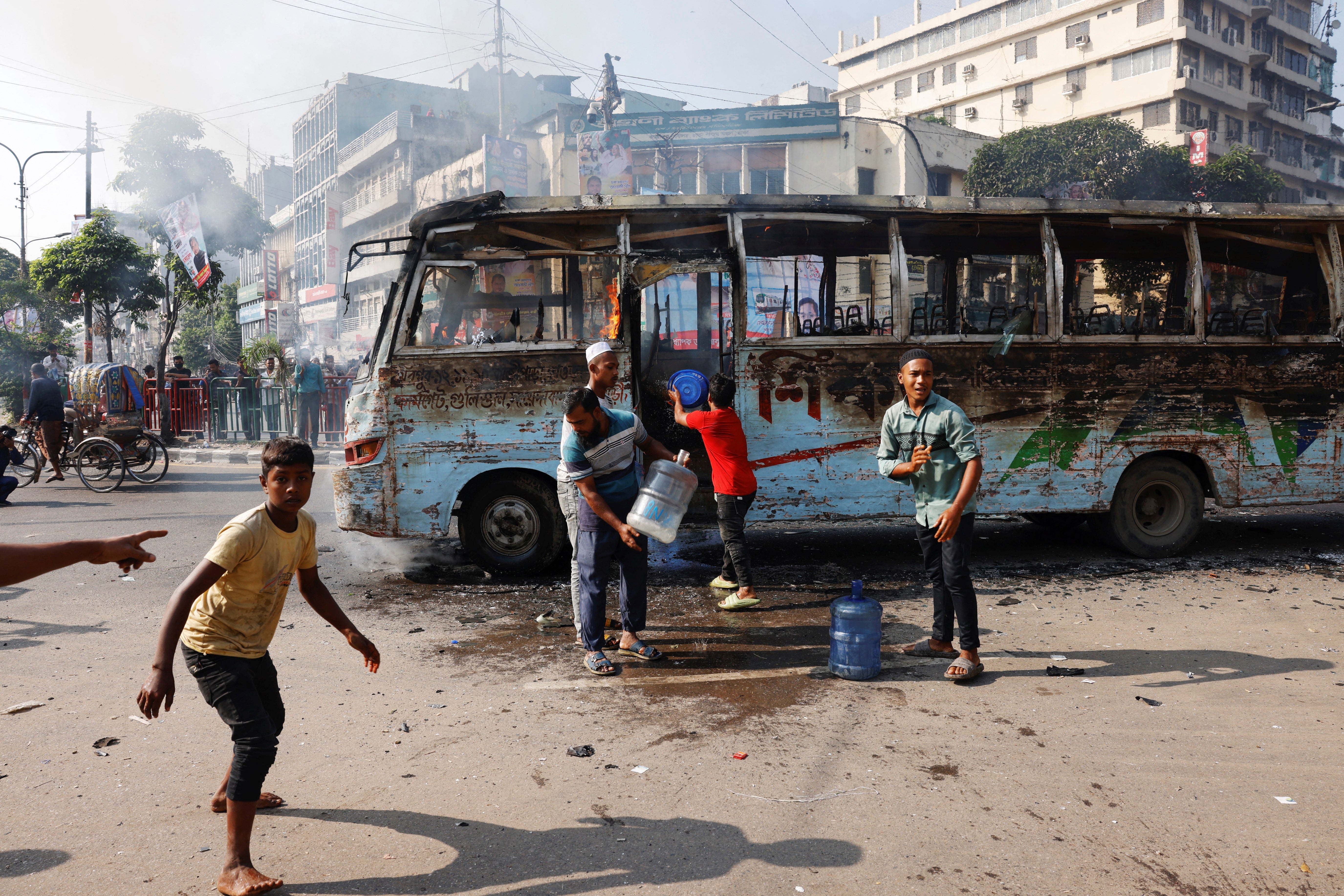 <p>People try to douse the fire after a public bus was set on fire during a countrywide strike from dawn to dusk called by the Bangladesh Nationalist Party (BNP), protesting against alleged police attacks on their Saturday rally in Dhaka, Bangladesh</p>