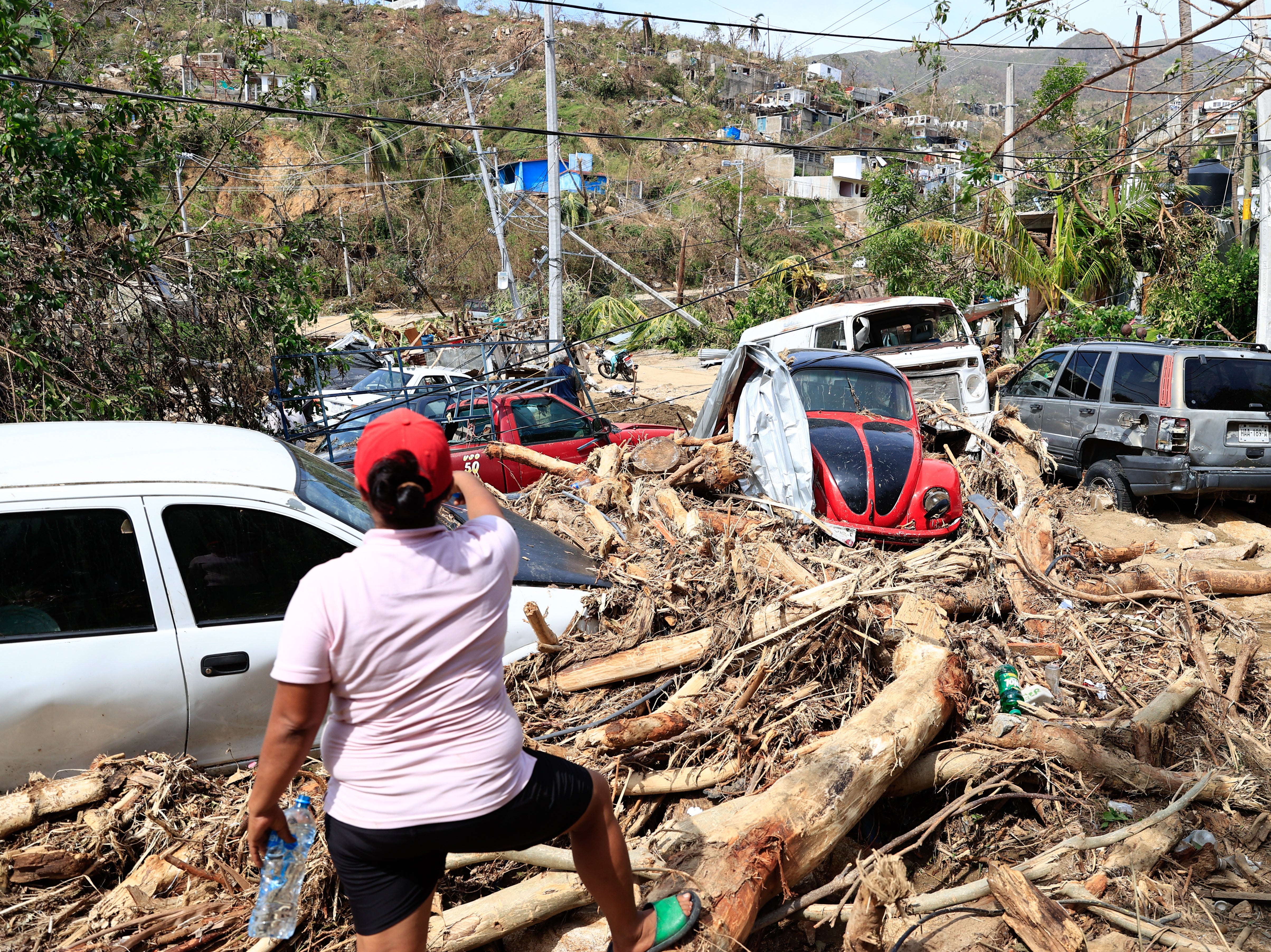 Damaged vehicles and downed trees in Acapulco after Hurricane Otis slammed into the coastal city last week