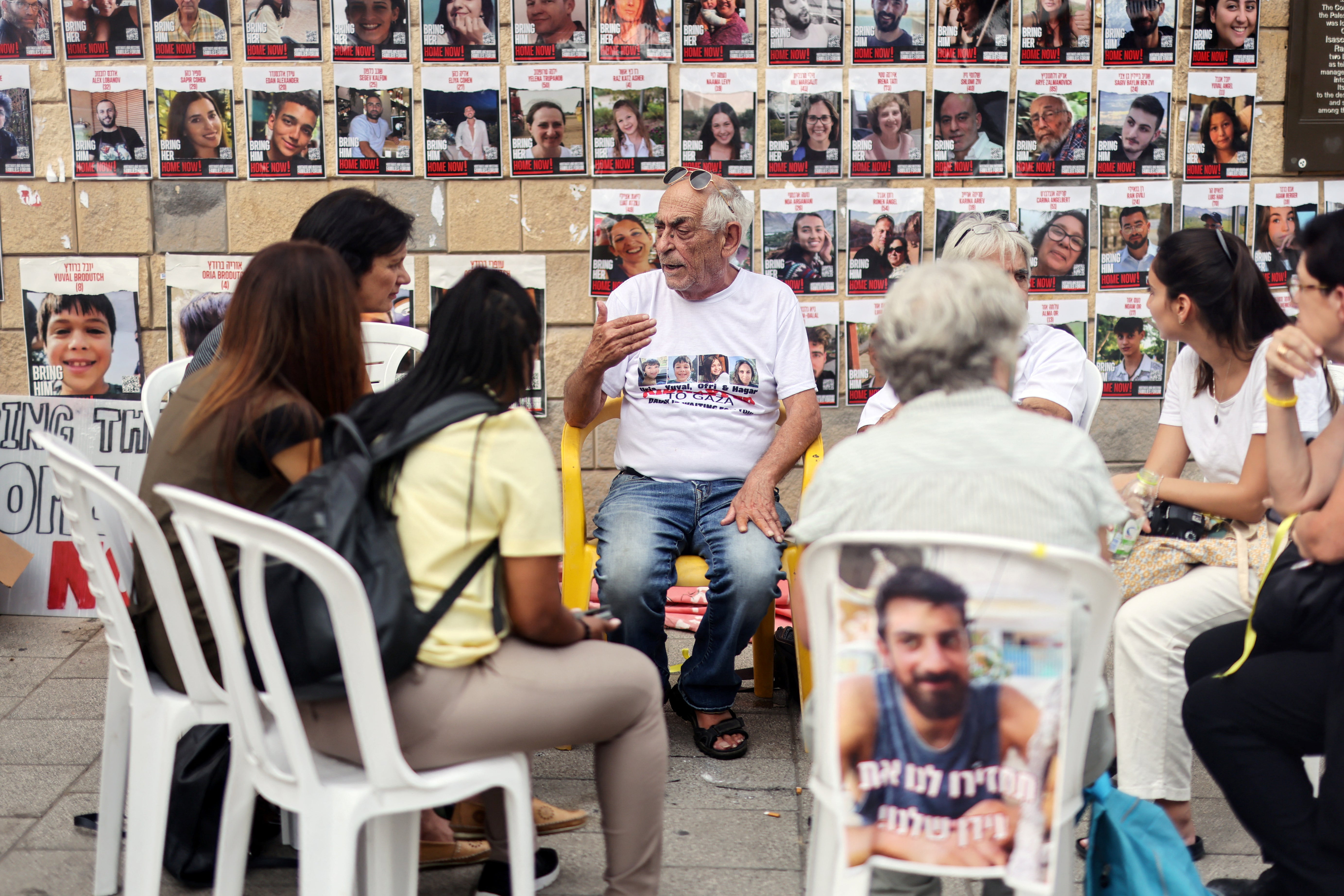 Relatives gather in front of images of those missing in Tel Aviv