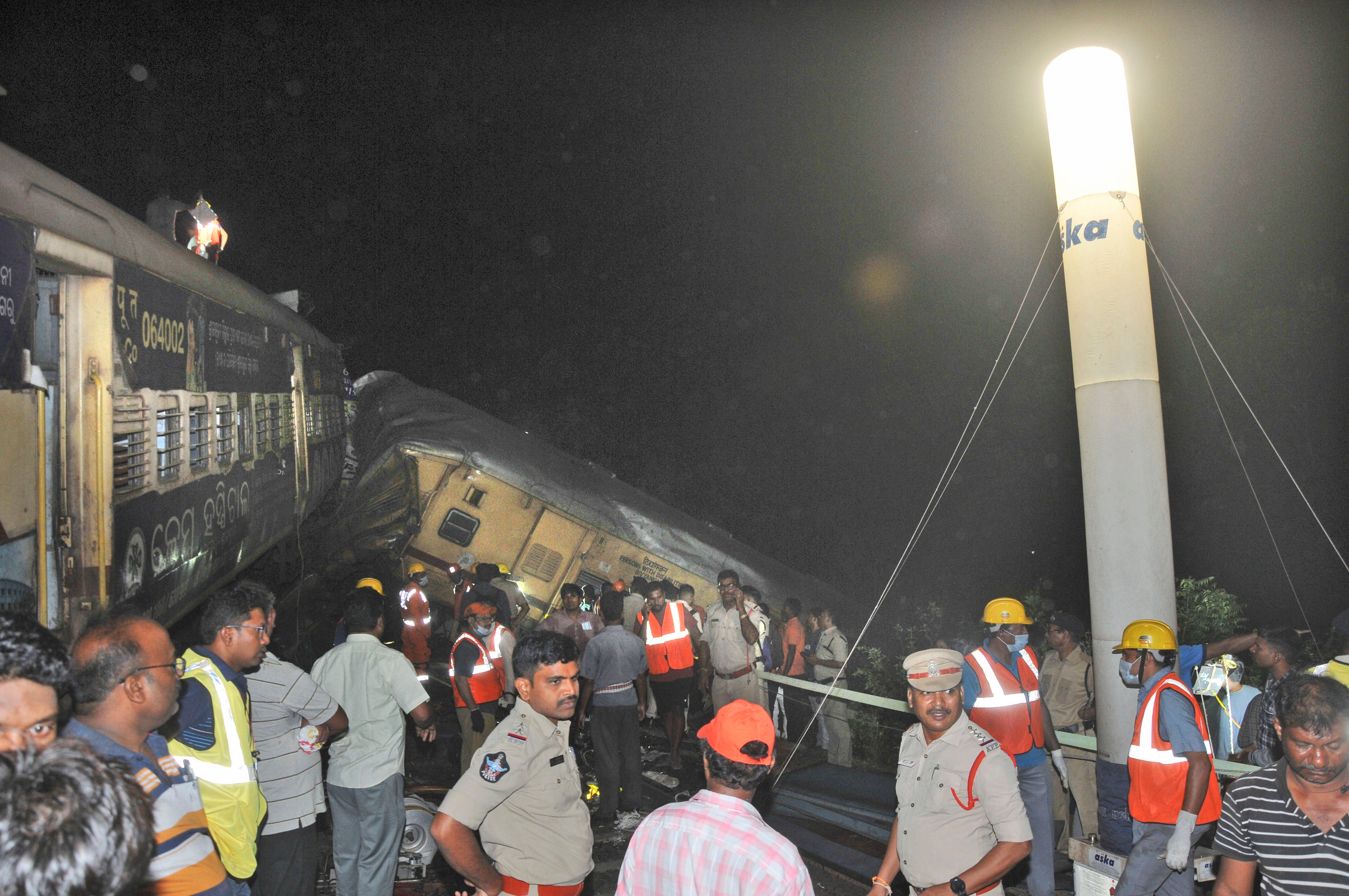 <p>Rescuers and others stand after two passenger trains collided in Vizianagaram district, Andhra Pradesh state</p>