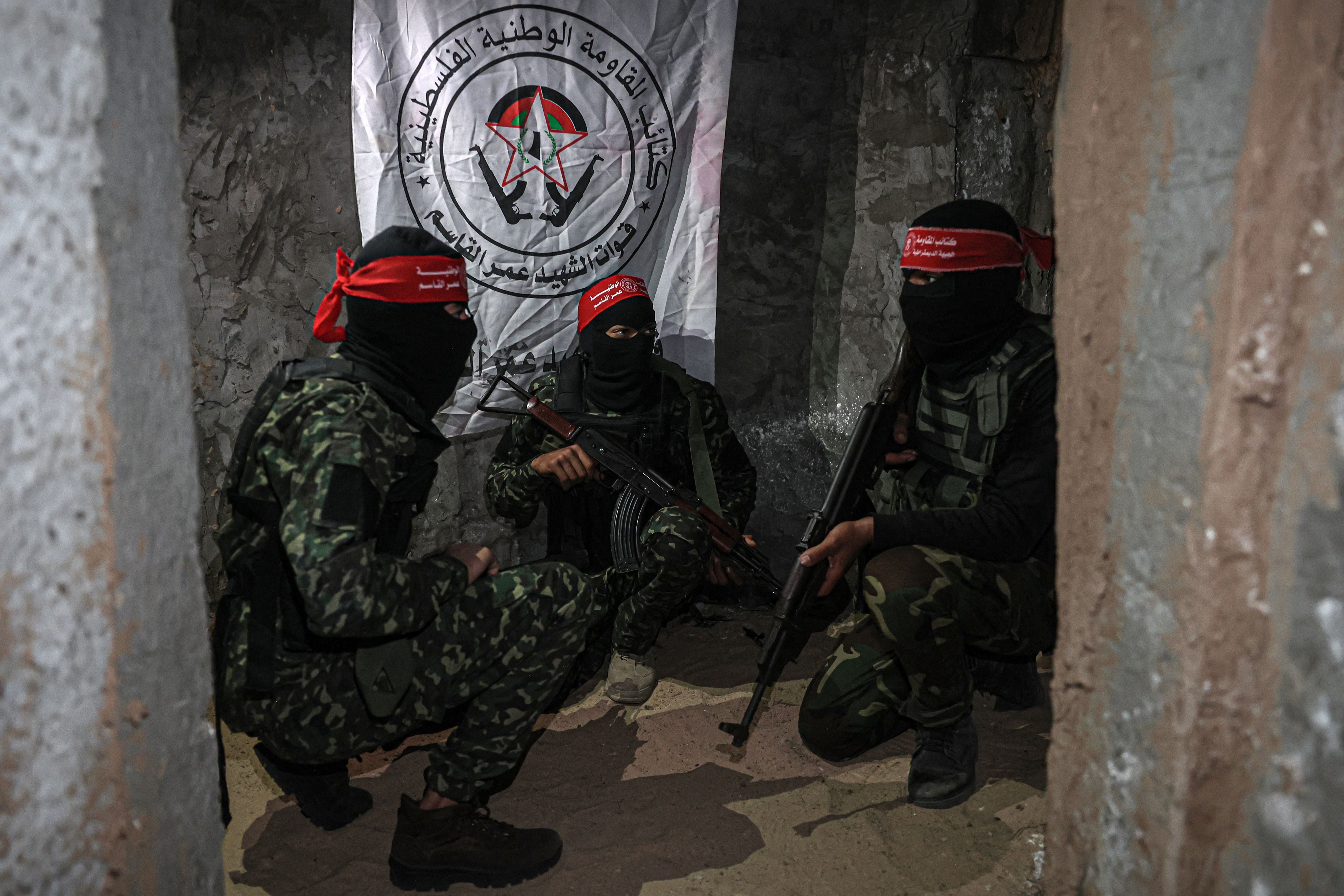 Fighters from the Democratic Front for the Liberation of Palestine (DFLP) walk in a tunnel in the southern Gaza Strip