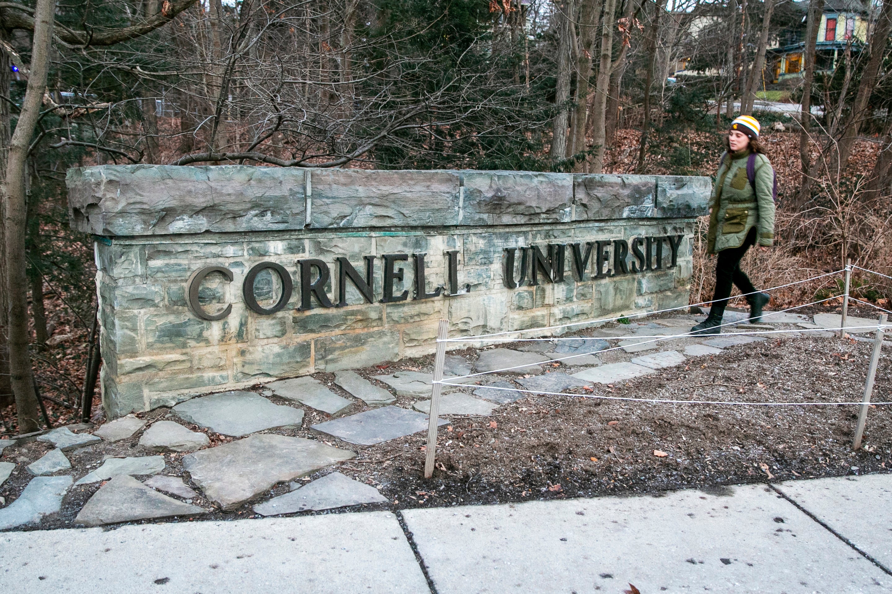 FILE - A woman walks by a Cornell University sign on the Ivy League school's campus in Ithaca, New York, on Jan. 14, 2022