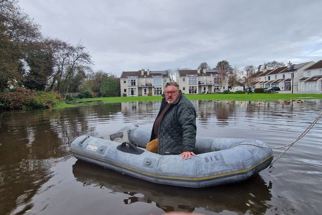 Councillor Jim Codd examines the flooding in the Haven estate in Rosslare from a dinghy (Jim Codd/PA)