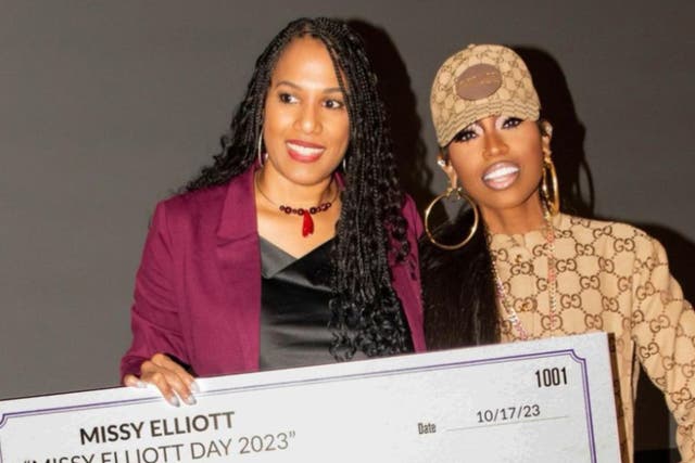 <p>Missy Elliot and Alisa Winston posing with a giant check of $50,000 donated to the Portsmouth Redevelopment and Housing Authority</p>