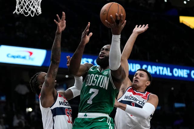 Boston Celtics guard Jaylen Brown shoots over Washington Wizards guard Delon Wright, left, and guard Johnny Davis (Mark Schiefelbein/AP)