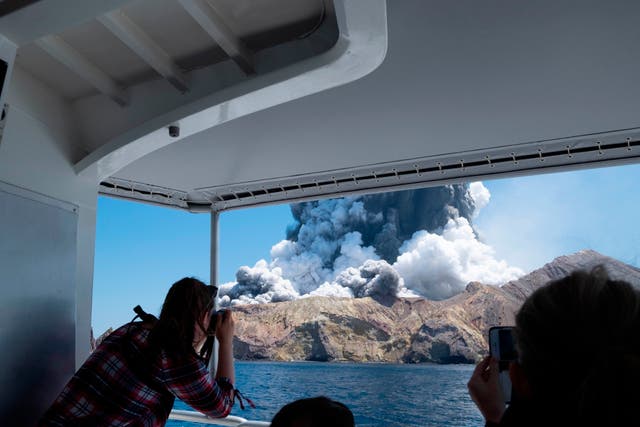 <p>Tourists on a boat look at the eruption of the volcano on White Island, New Zealand on 9 Demember 2019</p>