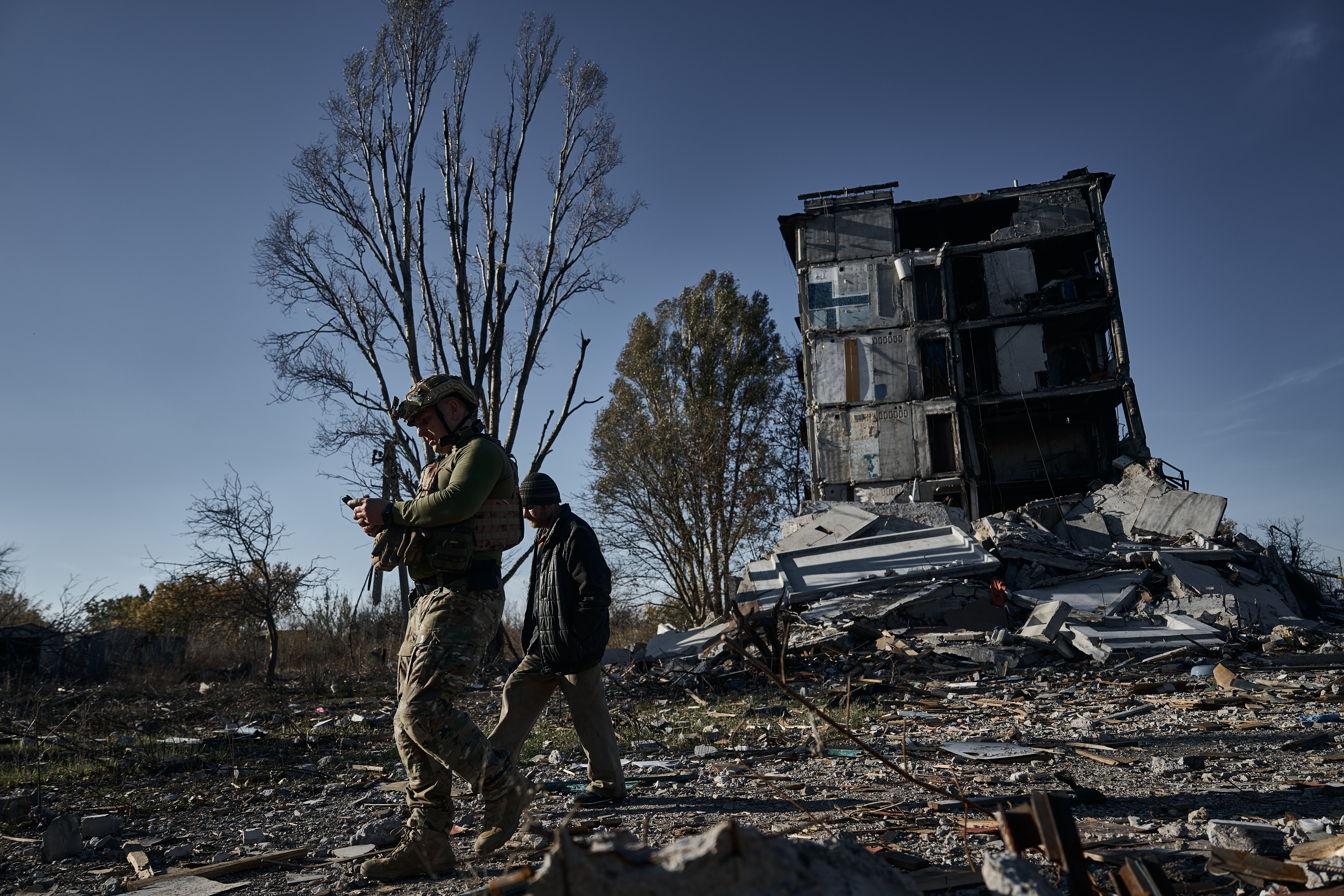 A police officer convinces a resident to evacuate his home amid intense fighting in Avdiivka, Ukraine