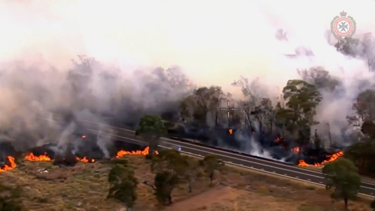A wildfire raging for a week in eastern Australia claims a life and razes more than 50 homes