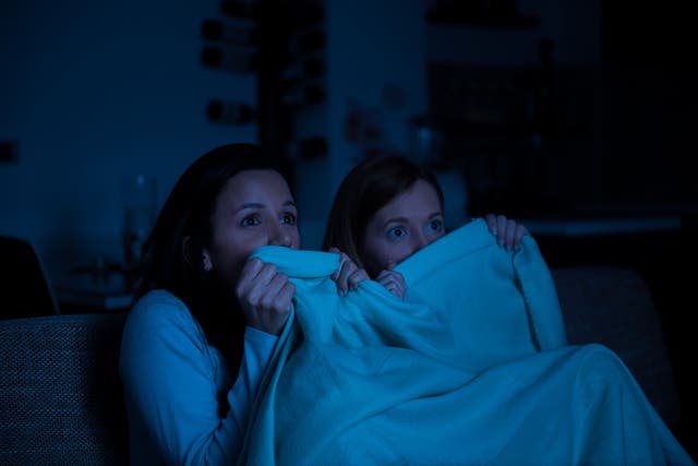 <p>Dos mujeres viendo una película de terror en la televisión juntas  </p>