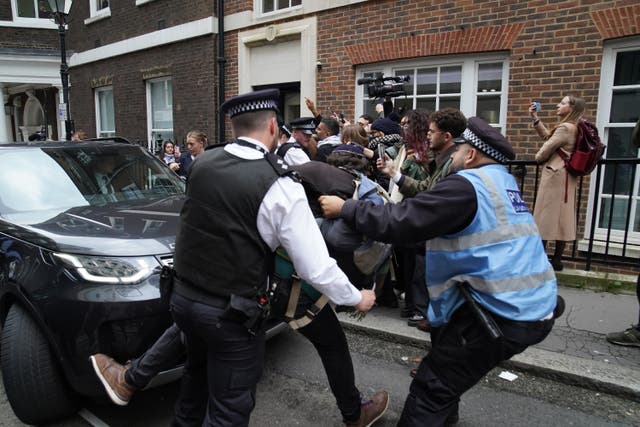 <p>Police officers move a man trying to block Labour leader Sir Keir Starmer’s car as he leaves, following his speech on the situation in the Middle East at Chatham House in central London (Stefan Rousseau/PA)</p>