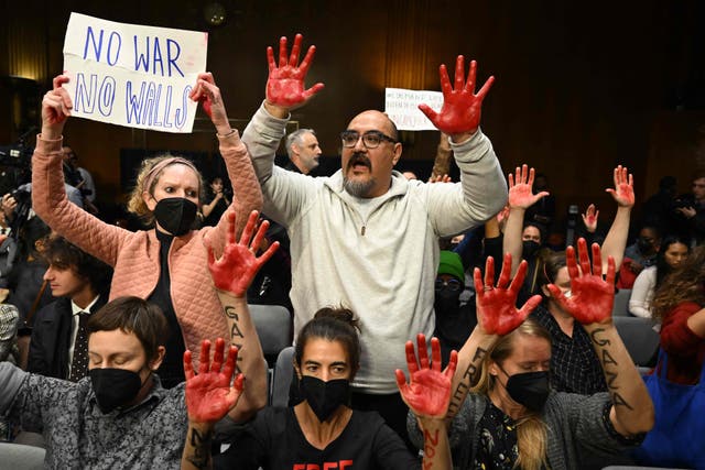 <p>Protesters raise their painted hands as US Secretary of State Antony Blinken and Defense Secretary Lloyd Austin testify during a Senate Appropriations Committee hearing to examine the national security supplemental request</p>
