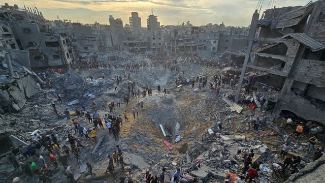 <p>Palestinians search for survivors at the site of Israeli strikes on houses in the Jabaliya refugee camp</p>