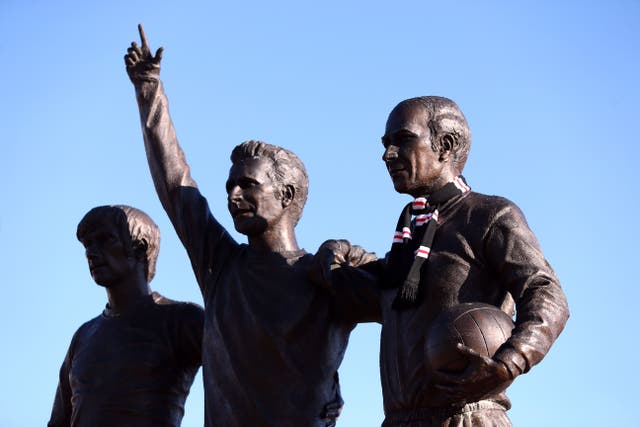 Tributes have been left on the United Trinity statue of, left to right, George Best, Denis Law and Sir Bobby Charlton (Barrington Coombs/PA)