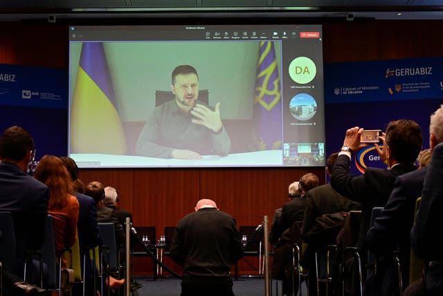 <p>Ukrainian president Volodymyr Zelensky is seen on a screen speaking during the German-Ukrainian business forum in Berlin</p>