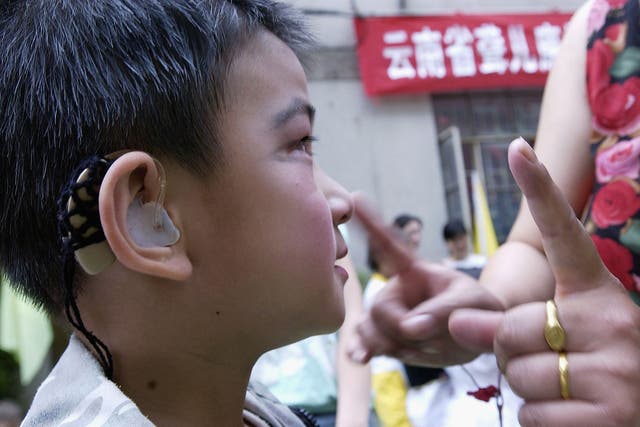 <p>A deaf child takes instructions before a performance to celebrate International Children’s Day at a rehabilitation centre for deaf children June 1, 2005 in Kunming, Yunnan Province, China</p>