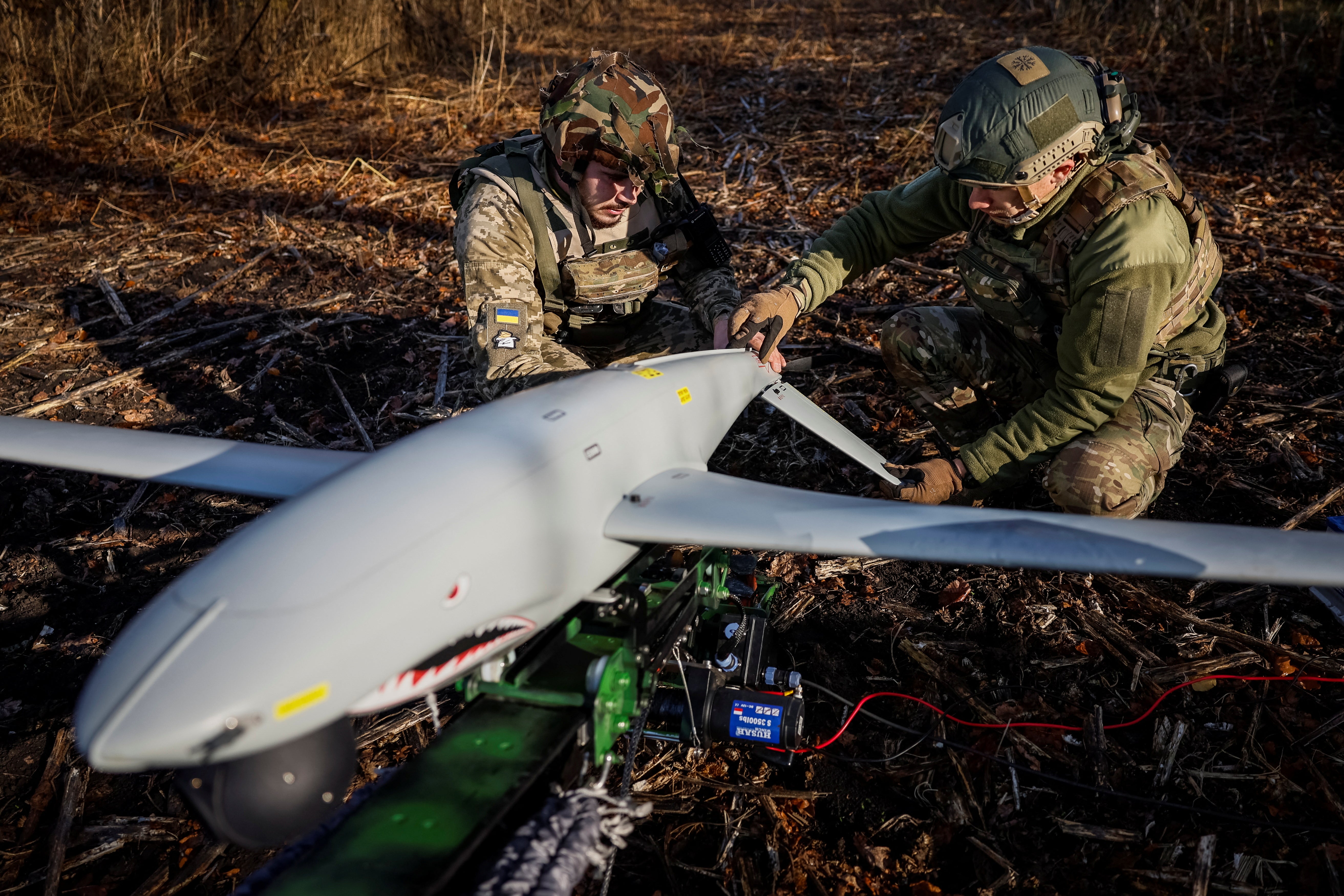 Two Ukrainian soldiers check a Shark drone before launching it at a Russian position in Kharkiv, Ukraine