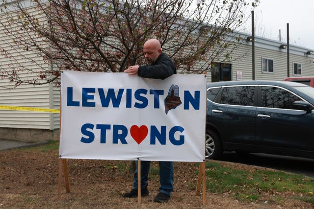 <p> A resident places a Lewiston Strong sign outside of the Schemengees Bar</p>