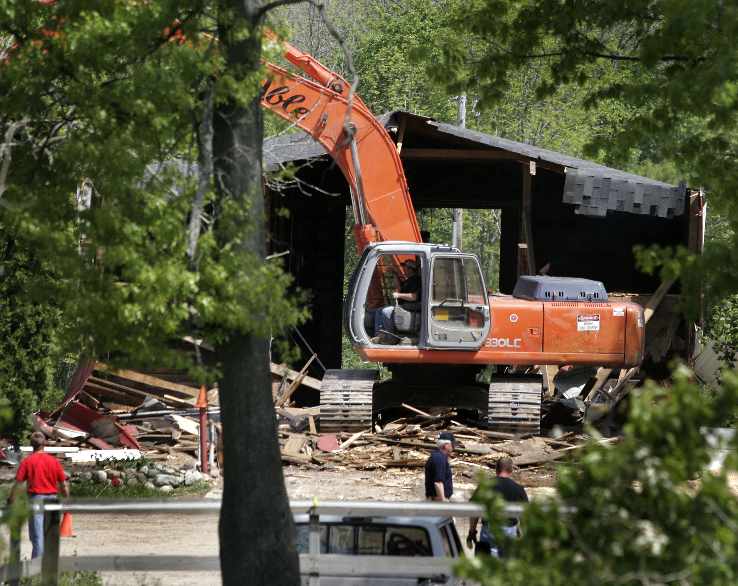 Demolition workers tear down a horse barn for the FBI during the search for Jimmy Hoffa's body at the Hidden Dreams Horse Farm May 24, 2006 in Milford, Michigan