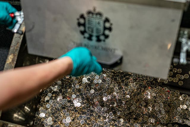 Thousands of newly minted £1 coins collect in a bin at the Royal Mint in Llantrisant, Pontyclun (Ben Birchall/PA)