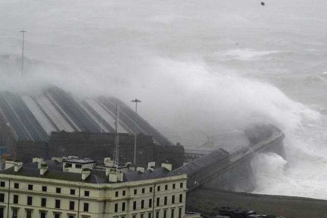 <p>Waves crash over the harbour wall in Folkestone, Kent</p>