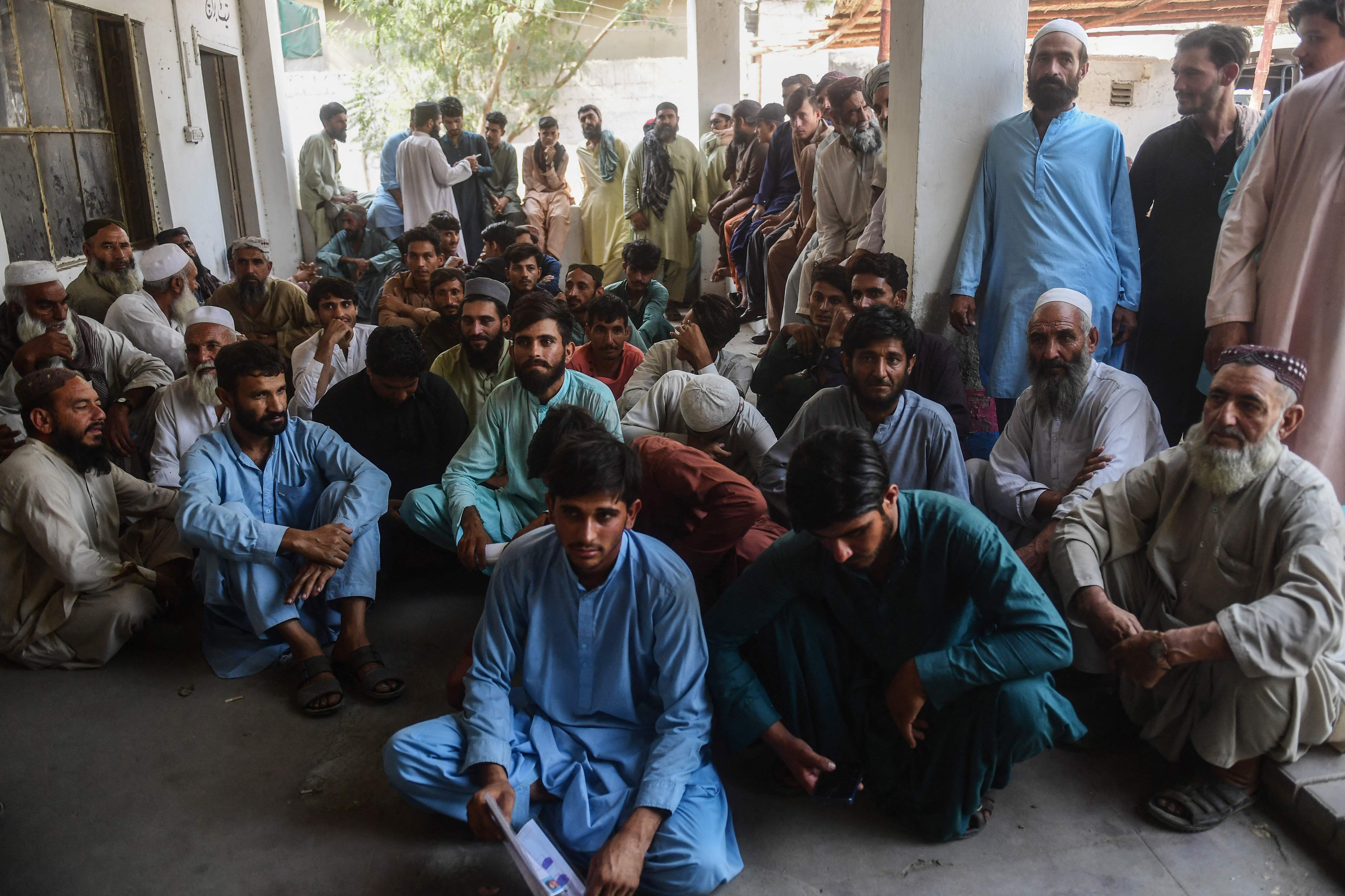 Detained Afghan refugees sit at a police station in Karachi on November 2, 2023, following a police operation against illegal Afghan immigrants.