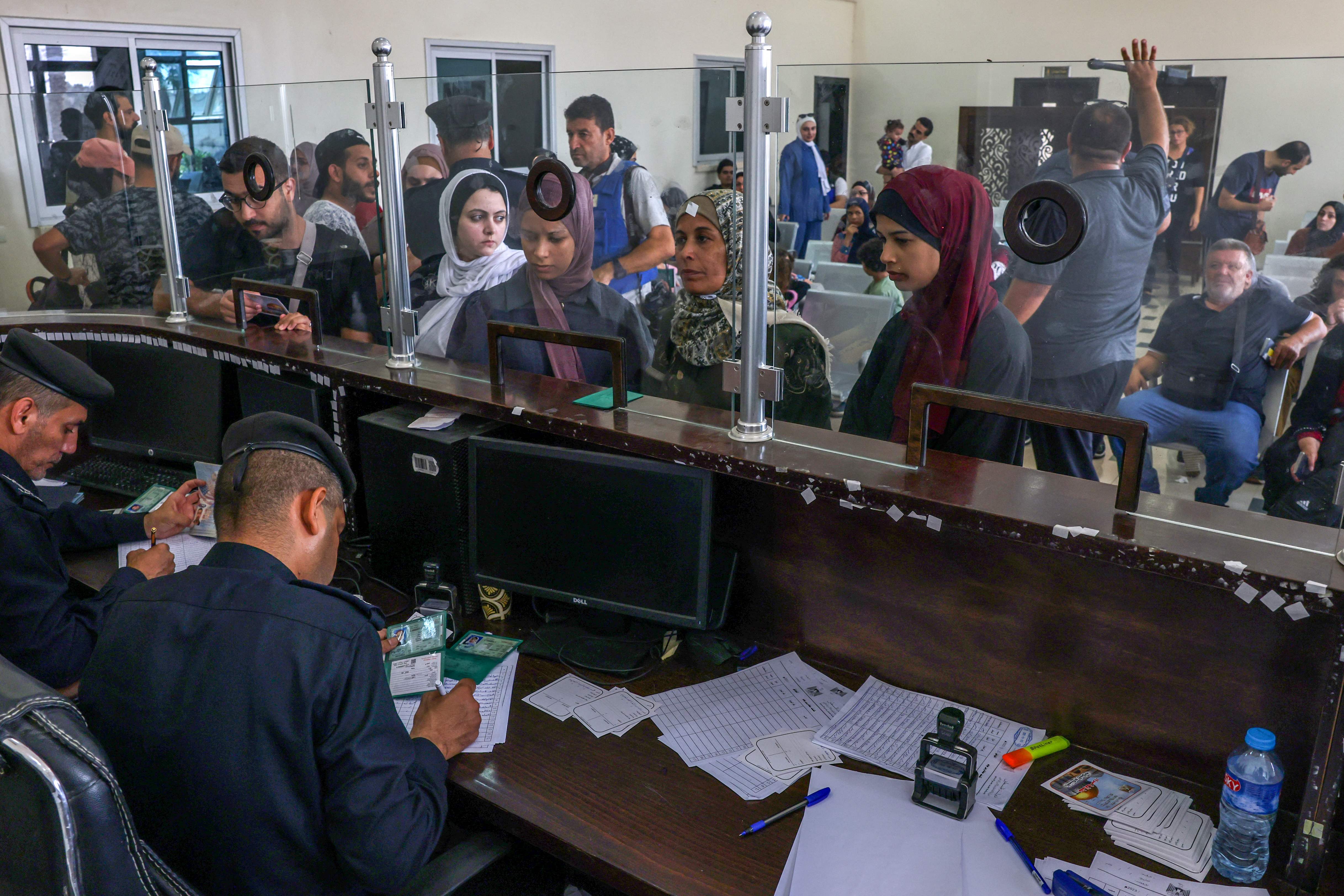 Egyptian border guards check the documents of people leaving Gaza