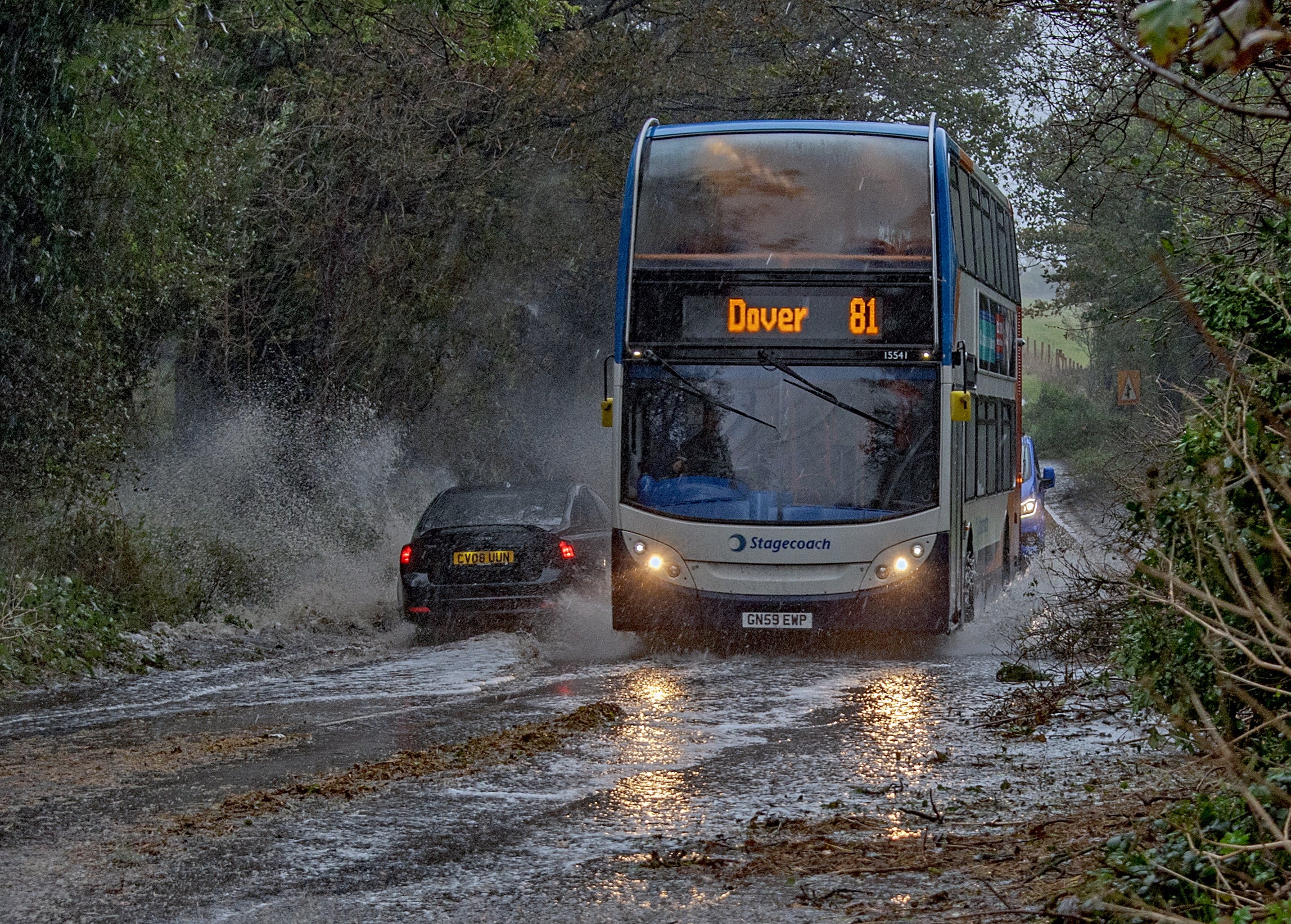 A bus makes its way through heavy rain and muddy roads during Storm Ciarán in Dover, England