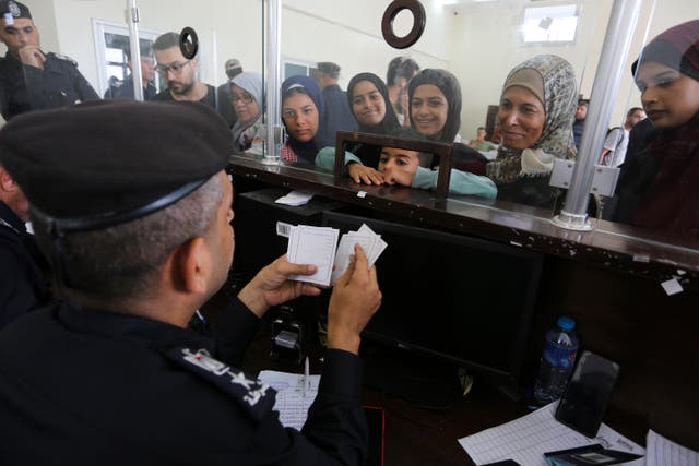 Palestinians with dual nationality register to cross to Egypt on the Gaza Strip side of the border crossing in Rafah (Hatem Ali/AP)