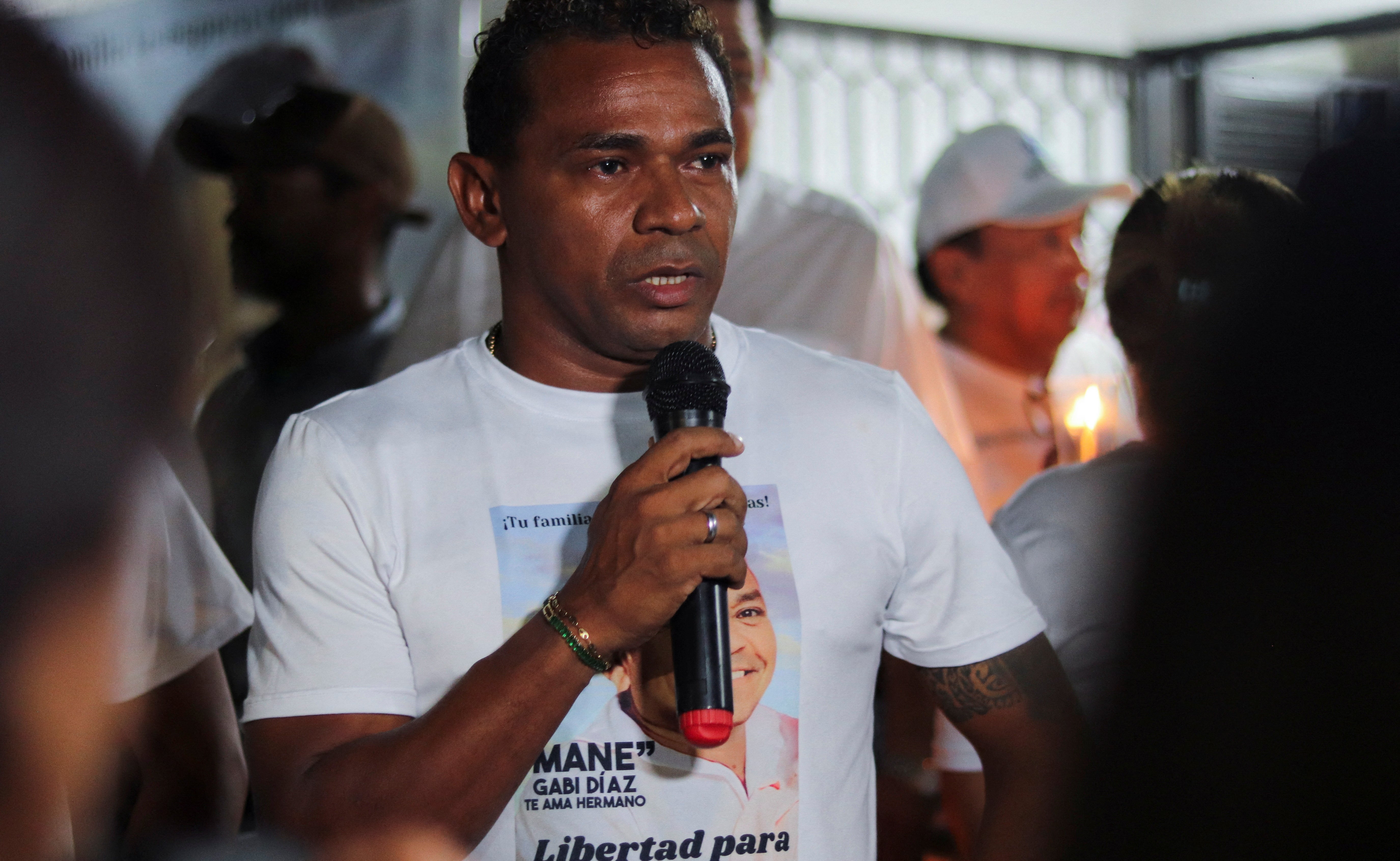 Yelquis Diaz, brother of Luis, speaks during a candlelight vigil demanding the release of their father