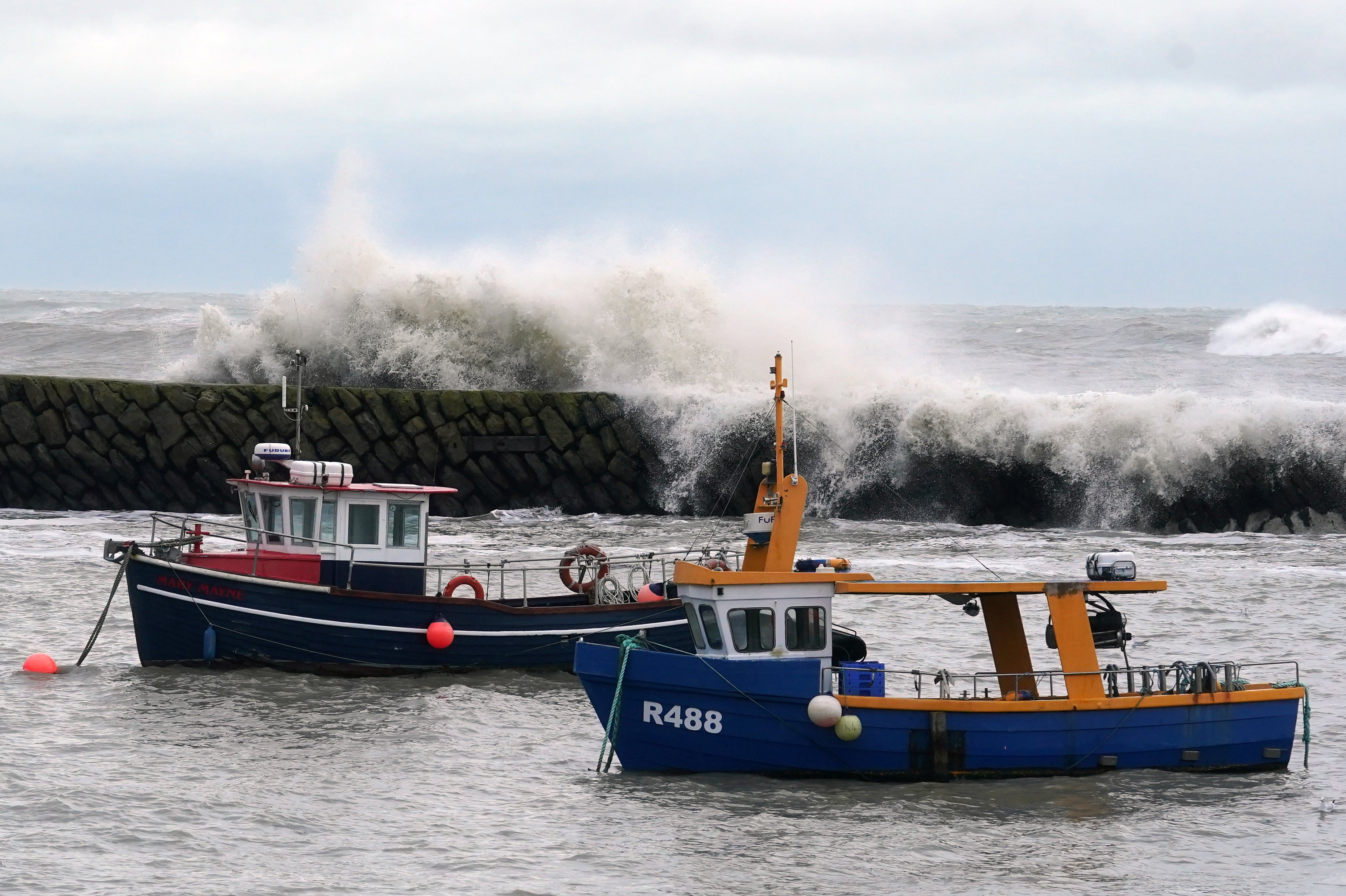 Waves crash behind fishing boats at Folkestone harbour, Ken