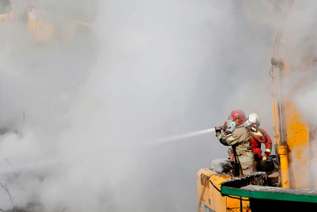 <p>File: An Iranian fireman sprays water </p>