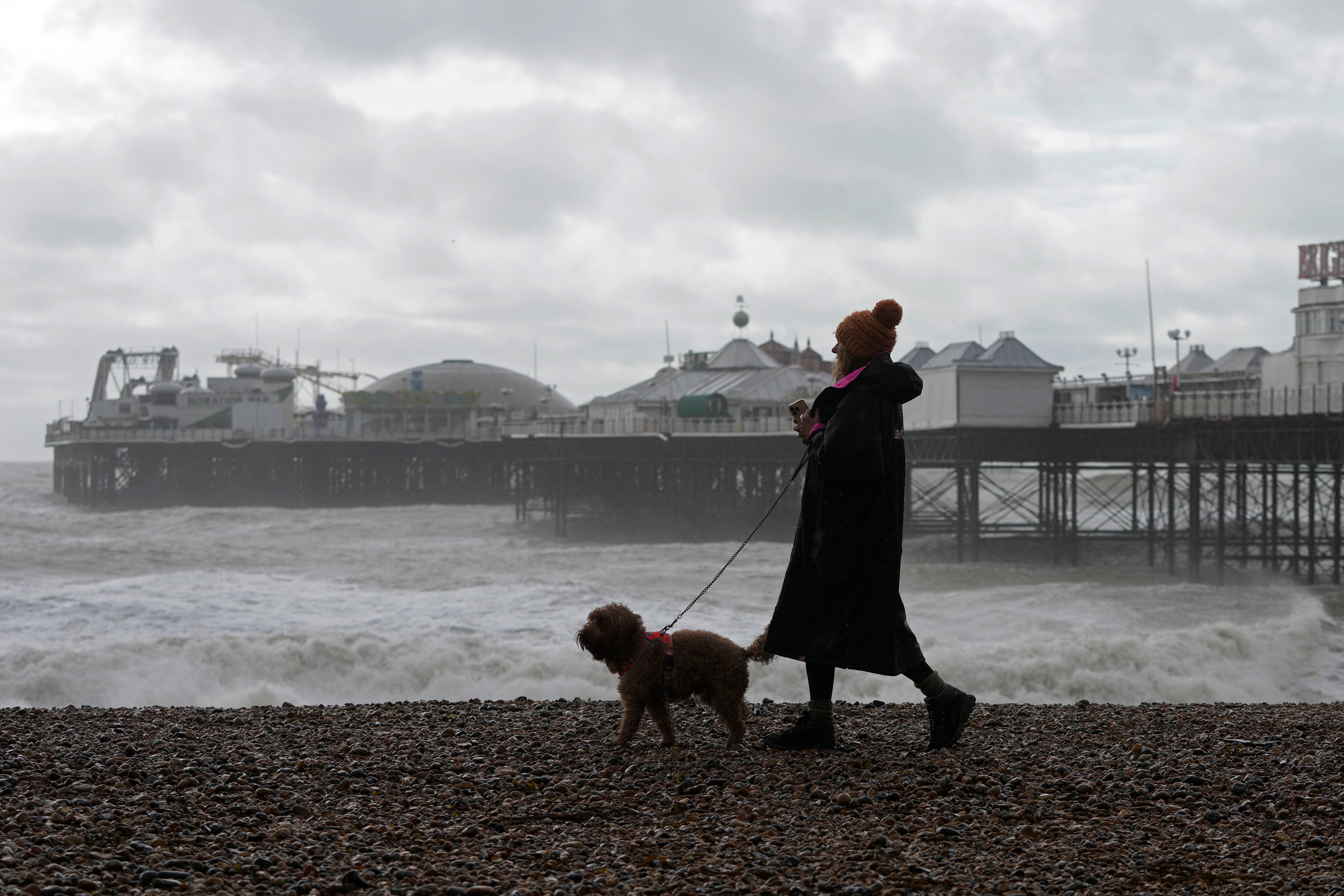A woman walks her dog as Storm Ciaran brings high winds and heavy rain along the south coast of England, in Brighton,