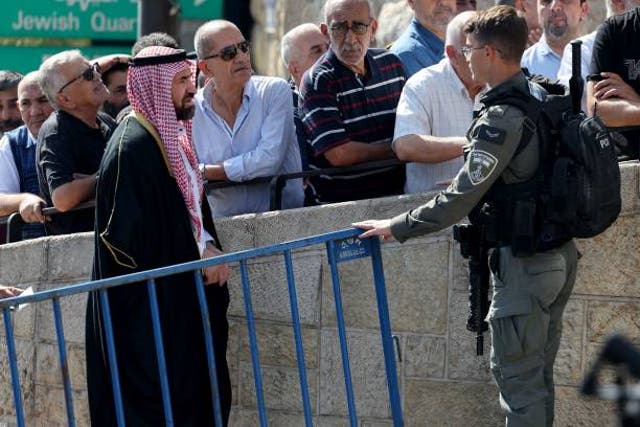 <p>An Israeli border police officers speaks to a Palestinian Muslim worshipper arriving at the Lion's Gate to make their way to the the Al-Aqsa Mosque compound for the Friday Noon</p>