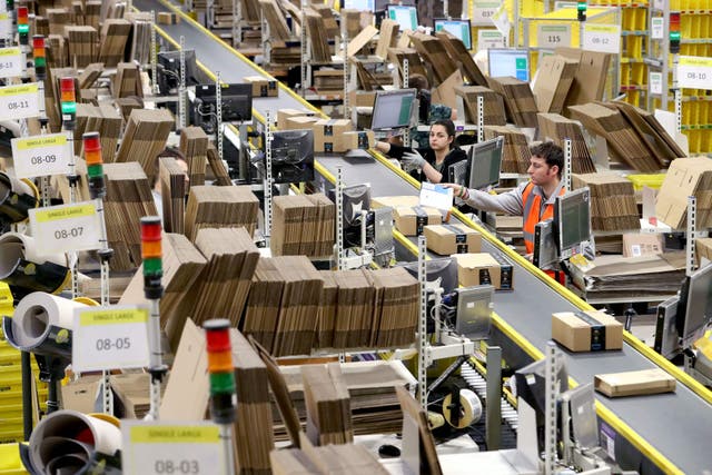 Staff label and package items in the on-site dispatch hall inside one of Britain’s largest Amazon warehouses in Dunfermline, Fife. The CMA said it had secured the new commitments on competitive practices from both Amazon and Meta (Jane Barlow/PA)