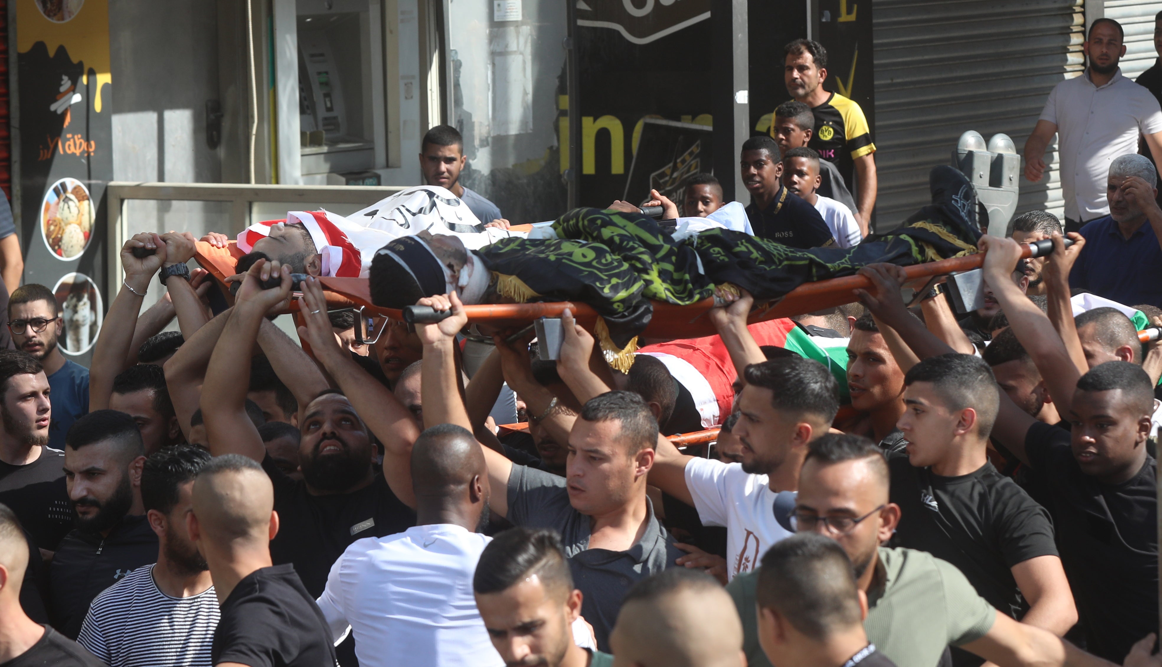 Mourners carry the bodies Palestinians killed during an Israeli raid at Jenin refugee camp