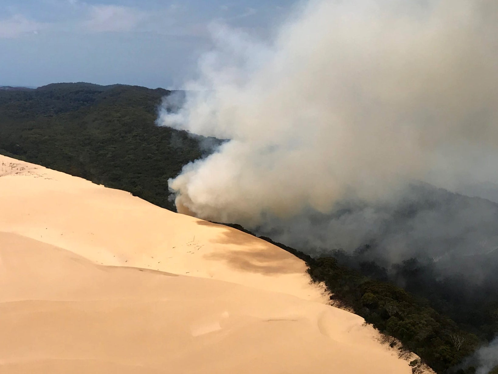 File. In this handout image provided by Queensland Fire and Emergency Services, bushfires continue to burn on 30 November 2020 on Fraser Island, Australia. [Representational]