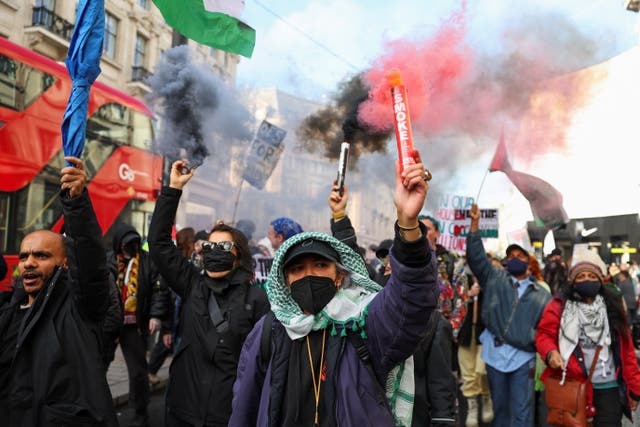 <p>Demonstrators in central London hold smoke flares as they protest in solidarity with Palestinians in Gaza</p>