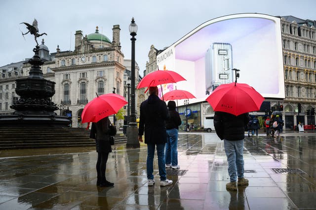 <p>People with umbrellas in the wet weather in Piccadilly Circus, London</p>