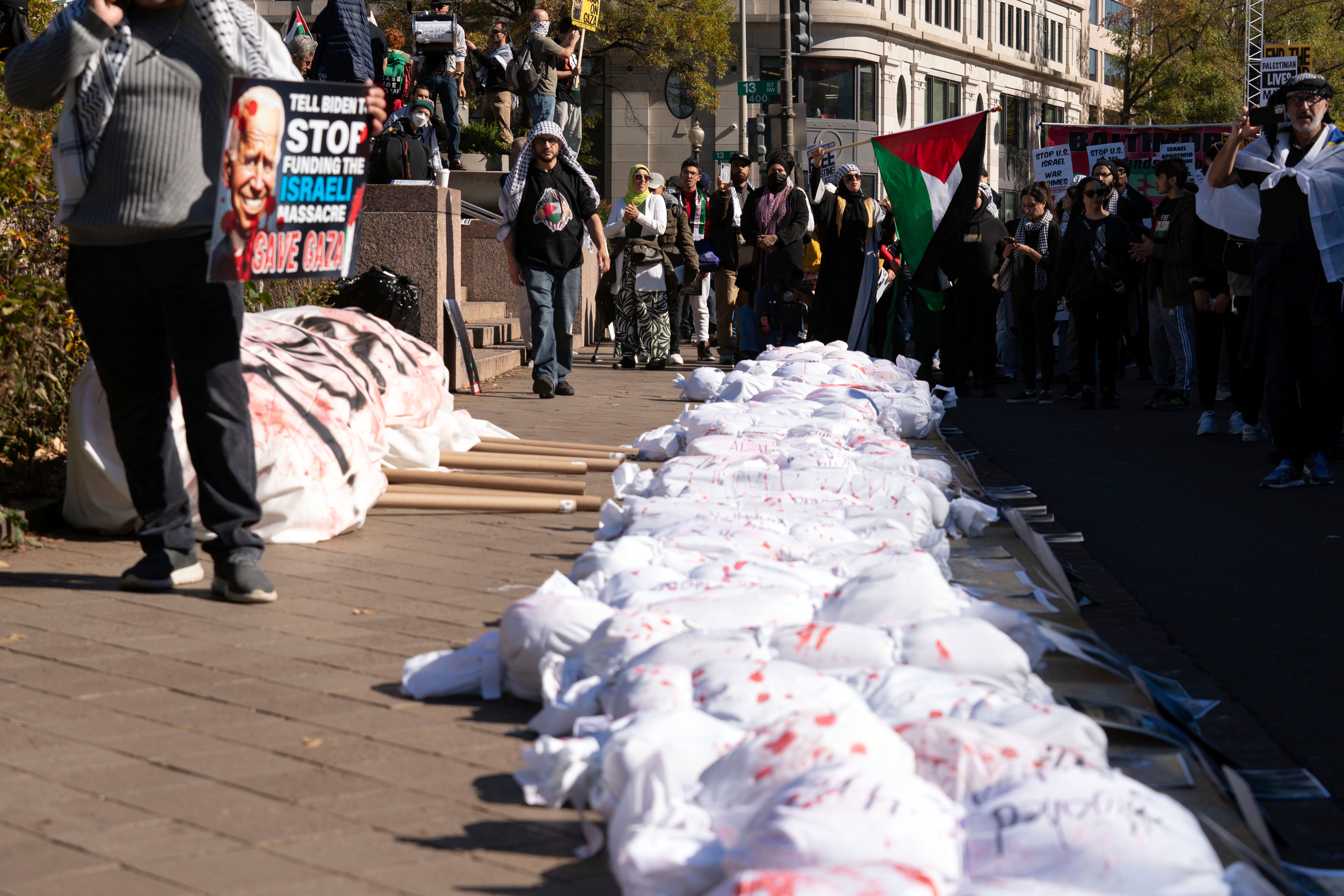 Protesters place white sacks representing the bodies of people killed in Gaza during a pro-Palestinian demonstration at Freedom Plaza in Washington, Saturday, Nov. 4, 2023