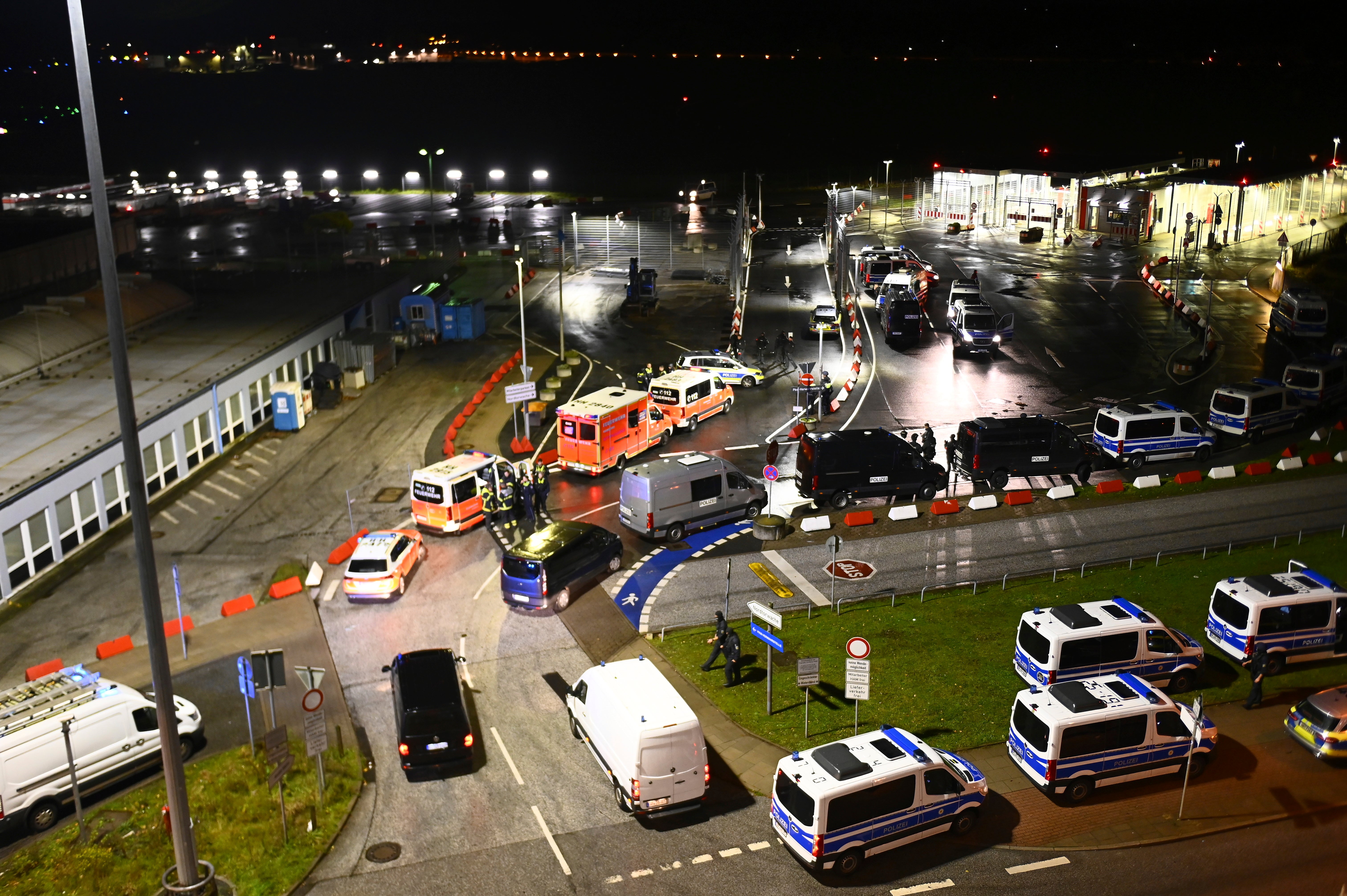 <p>Police vehicles and ambulances arrive at Hamburg airport after an armed man drove through a gate</p>