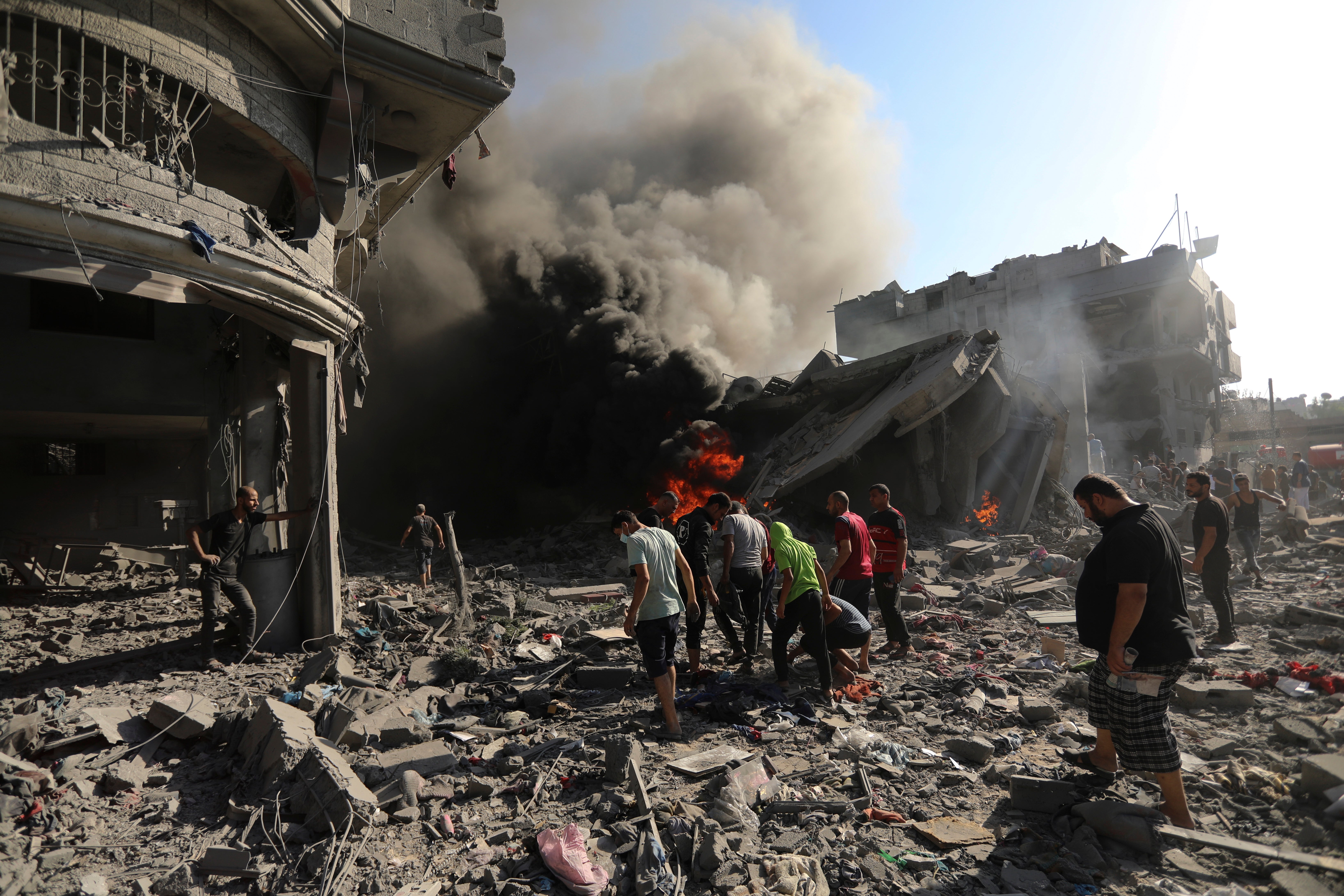 Palestinians inspect the damage of a house destroyed by an Israeli airstrike in Gaza City