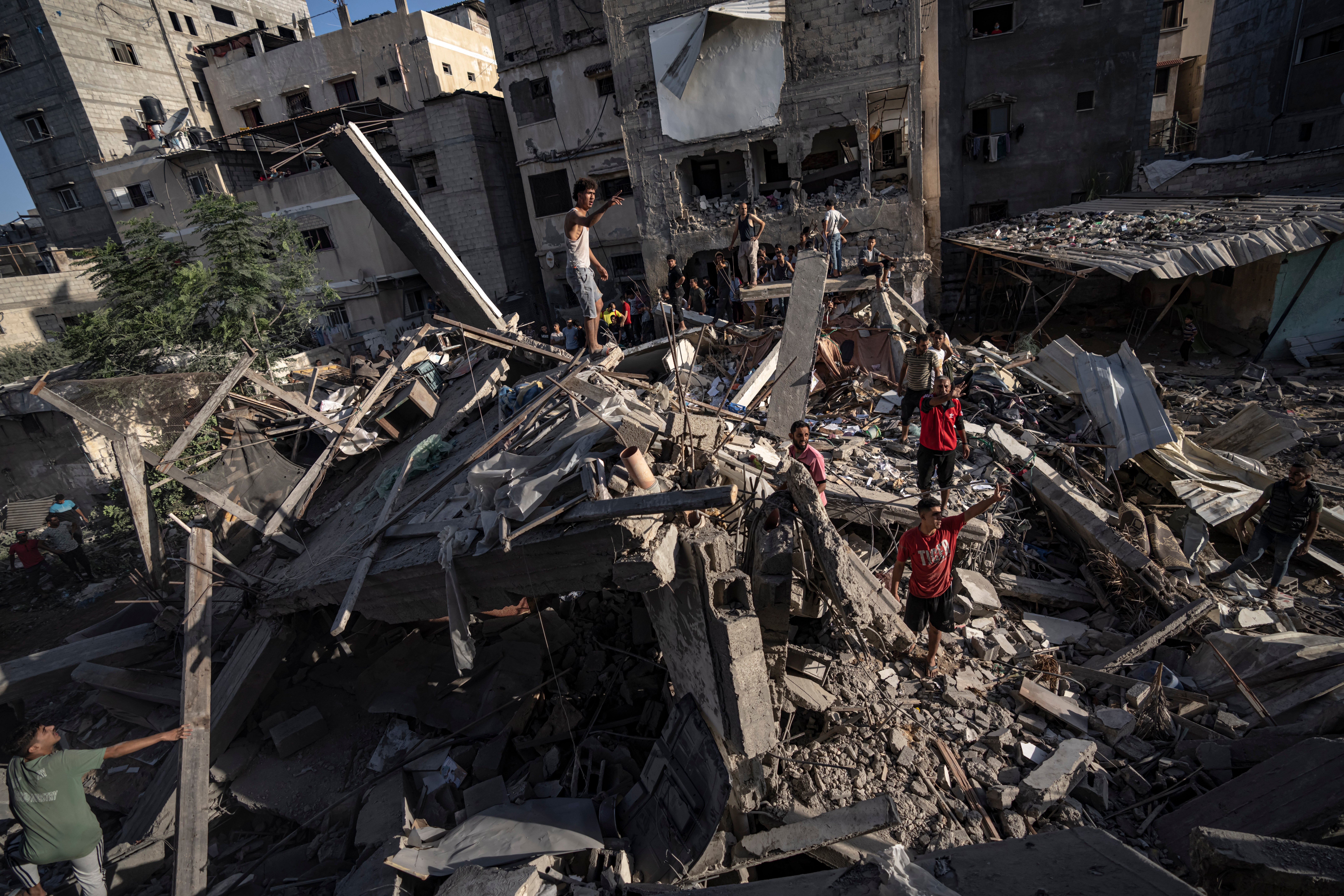 Palestinians look at the destruction after Israeli strikes on the Gaza Strip in Khan Younis